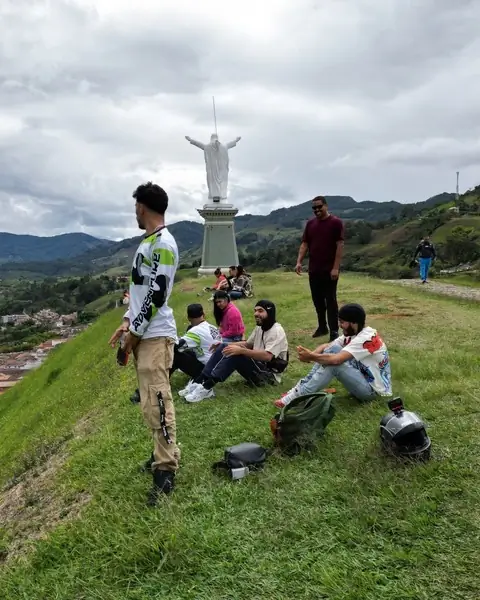 Grupo de pilotos descansando junto a una estatua de Cristo en lo alto de un pueblo