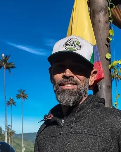 Guía con gorra de Adventure Moto Tour y una bandera de Colombia